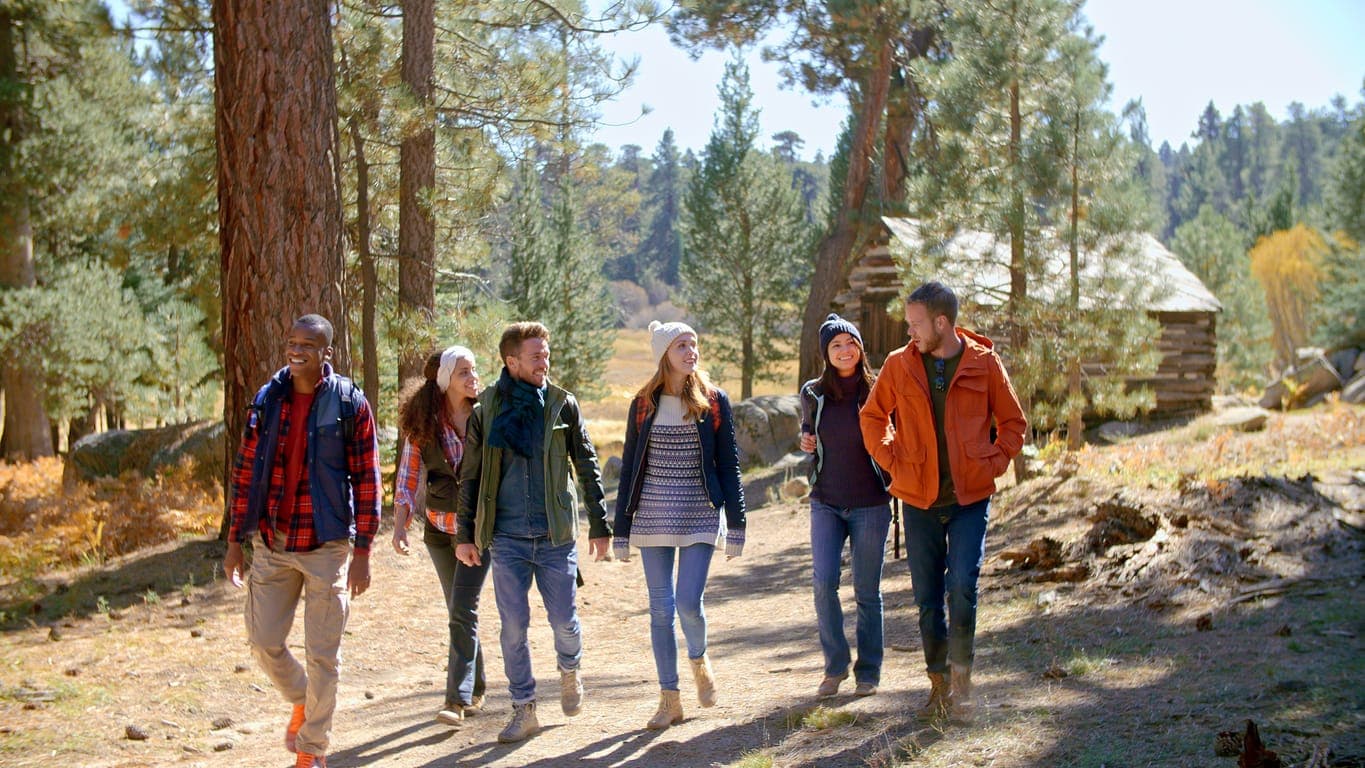 A team of six hikers walking together along a mountain trail